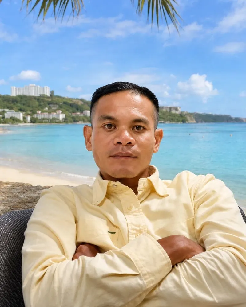 Portrait of Vincent Villagomez seated by the beach with his arms crossed
